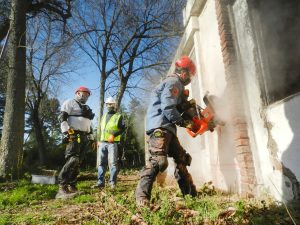 men demolishing a concrete house